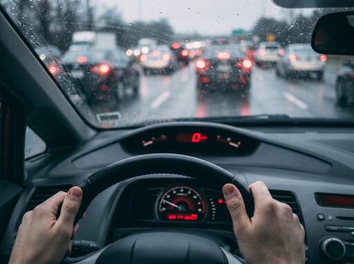 Nat asfalt op een Nederlandse snelweg met remmende auto's in de regen