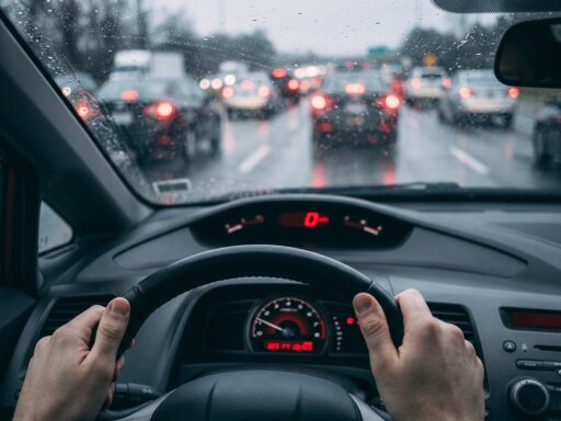 Nat asfalt op een Nederlandse snelweg met remmende auto's in de regen