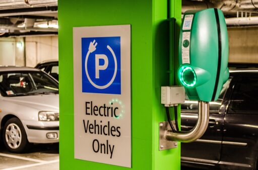 Drie betaalbare elektrische auto's aan laadpalen in een parkeergarage